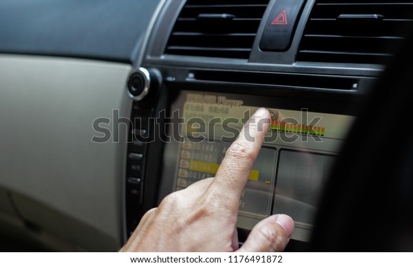 hand touch display monitor to\
play music in a car, selective focus , transportation\
concept.