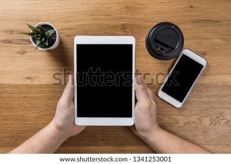 Hand touch on empty screen of tablet above brown table top view, Leave space for display of your content, Technology concept, mock up for montage your content