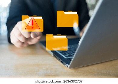 Hand touch a virtual folder with alert symbol. Cyberattacks on computer networks. Cybersecurity alert with digital file folder.