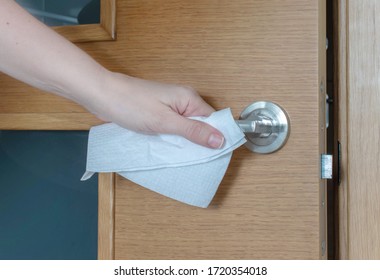 Hand touches a door handle through a paper serviette during a coronavirus epidemic. Transmission of the infection medical concept. 
Entry and exit safety protocol.
 - Powered by Shutterstock