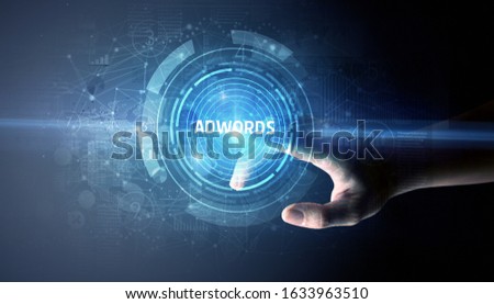 Hand touching ADWORDS button, modern business technology concept