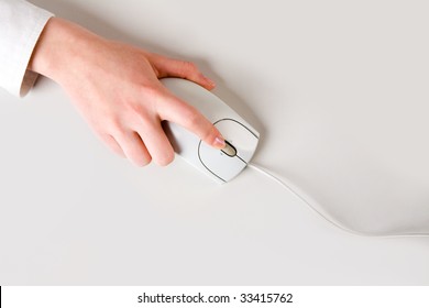 Woman?s Hand Touching Computer Mouse Placed On White Table