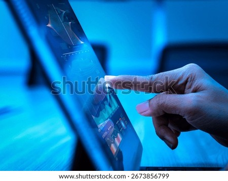 Hand touching digital tablet with data visualization graphs, representing business growth, financial investment, data analysis, AI technology, big data strategy, and future data center expansion.