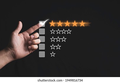 Hand touching and doing mark to five yellow stars on black background, the best customer satisfaction and evaluation for good quality product and service.