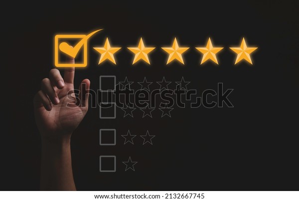 Hand touching and doing mark to five\
yellow stars on black background, the best customer satisfaction\
and evaluation for good quality product and\
service.