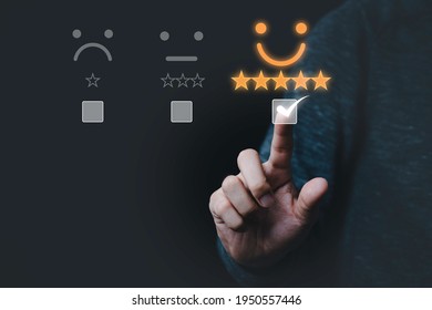 Hand touching and doing mark to select smiley face icon for evaluate product and service, customer satisfaction concept.