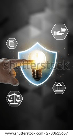 Hand touching a glowing lightbulb inside a shield, surrounded by legal icons. Represents intellectual property protection, patent law, innovation security, and copyright concept