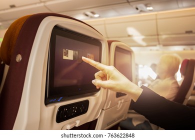 Hand Touching LCD At The Entertainment Screen In A Plane During Flight Time