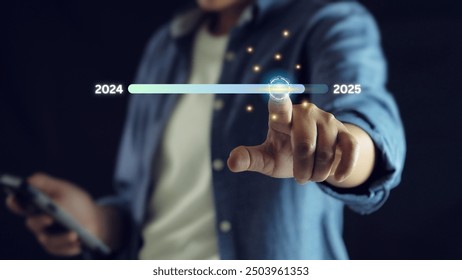Hand touching on download bar status to change from 2024 to 2025 for countdown of merry Christmas.Start new business and new life, Businessman touch on virtual bar status.