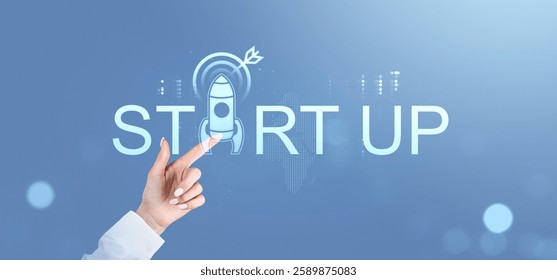 Hand touching startup text with rocket icon on a futuristic digital interface, blue background. Concept of business innovation and new beginnings