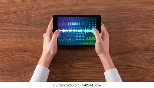 Hand touching tablet with waveforms and sound design concept