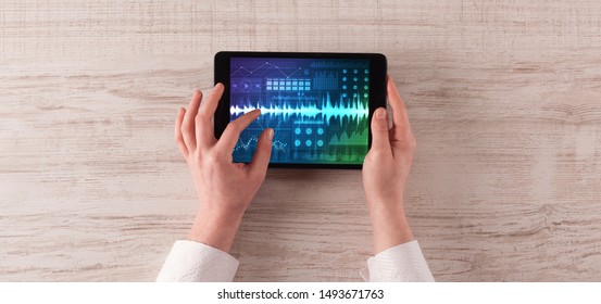 Hand touching tablet with waveforms and sound design concept