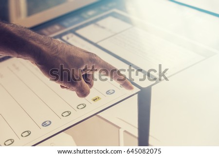 Hand touching touch screen. Asian, brown, hairy hand scrolling through list. Interactive screen