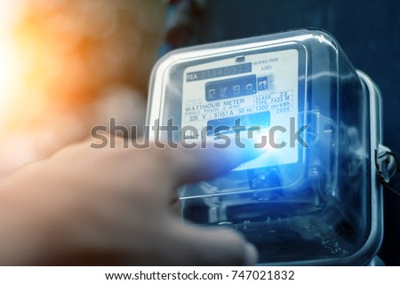Hand is touching the transformer with copy space.Incorrect energy detection method.Watthour meter of electricity for use in home appliance.Electronics