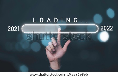 Hand touching to virtual infographic loading for change 2021 to 2022 , Countdown and preparation merry Christmas and happy new year concept.
