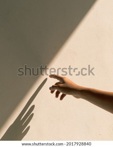 hand touching the wall exposed to sunlight.