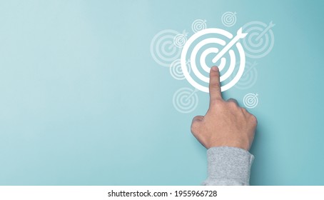 Hand touching white target board on blue background and copy space , Setup business goal and objective achievement concept.