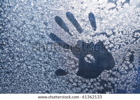 Hand trace on the frozen winter glass
