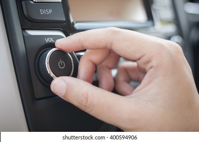 Hand tuning fm radio button in car panel.