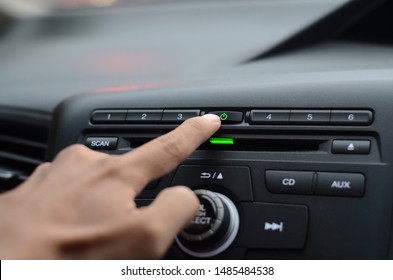 Hand Turn On The Radio In The Car.Hand Driver Touching The Screen And Turning On Car Radio System,Button On Dashboard In Car Panel