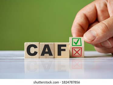 The hand turn wooden block with red reject X and green confirm tick as change concept of CAF. Word CAF conceptual symbol.