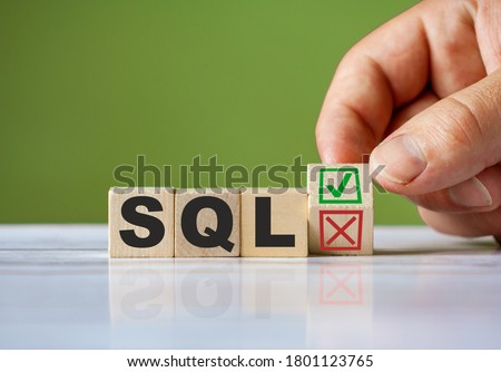 The hand turn wooden block with red reject X and green confirm tick as change concept of SQL language. Word SQL conceptual symbol.