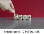 Hand turned a dice and form the expression SD WAN. Symbol for Software defined Wide Area Networking. Beautiful red background. Copy space.