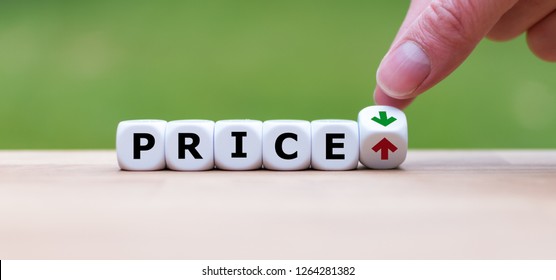 Hand is turning a dice and changes the direction of an arrow, symbolizing that the price is going down (or vice versa) - Shutterstock ID 1264281382