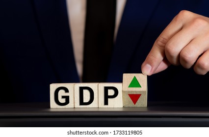 Hand Is Turning A Dice And Changes The Direction Of An Arrow Symbolizing That The GDP Of A Country Is Changing The Trend And Goes Up Instead Of Down