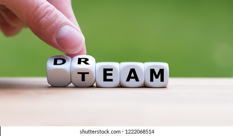 Hand is turning a dice and changes the word "dream" to "team"