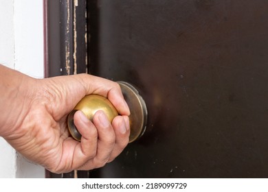 Hand Turning A Doorknob To Open Door