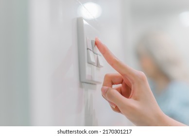 Hand Turning Off On Light Switch.