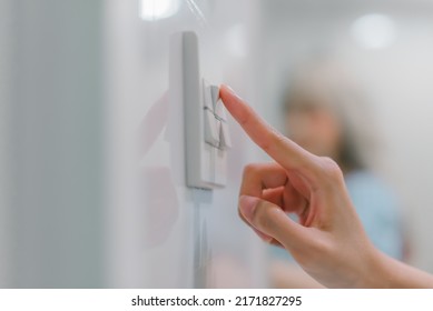 Hand turning off on light switch. - Shutterstock ID 2171827295