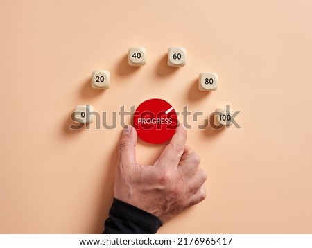 Hand turning progress level meter indicating high level of progression. Progress and performance growth or increase concept.