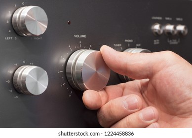 Hand Turning Up The Volume In A Stereo