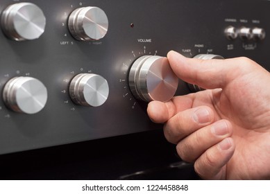 Hand Turning Up The Volume In A Stereo