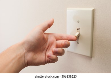 Hand turning wall light switch off. color image in horizontal orientation - Shutterstock ID 306139223