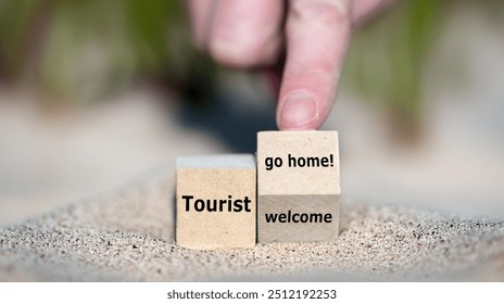 Hand turns cube and changes the expression 'tourist welcome' to 'tourist go home!'.
