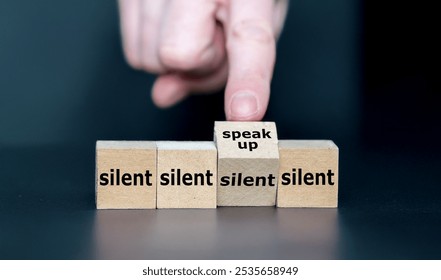 Hand turns cube and changes the expression 'silent' to 'speak up'.