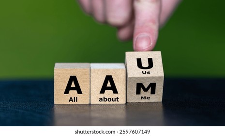 Hand turns cube and changes the expression AAM (all about me) to AAU (all about us).