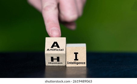 Hand turns cube and changes the expression HI (human intelligence) to AI (artificial intelligence).
