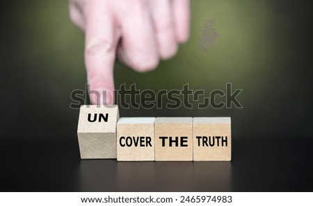 Hand turns cube and changes the expression 'cover the truth' to 'uncover the truth'.