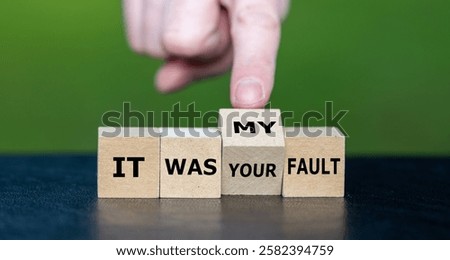 Hand turns cube and changes the expression 'it was your fault' to 'it was my fault'.