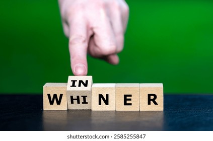 Hand turns cube and changes the word whiner to winner.