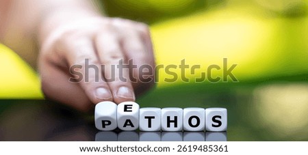 Hand turns cube and changes the word 'pathos' to 'ethos'.