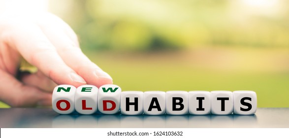 Hand turns dice and changes the expression "old habits" to "new habits".