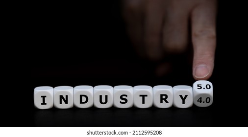 Hand turns dice and changes the expression "industry 4.0" to "industry 5.0". - Shutterstock ID 2112595208