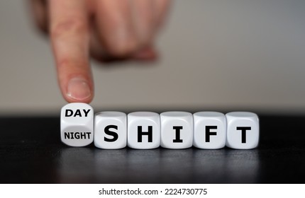 Hand turns dice and changes the  expression 'day shift' to 'night shift'. - Shutterstock ID 2224730775