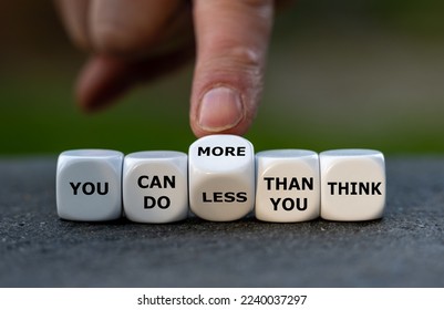 Hand turns dice and changes the expression 'you can do less than you think' to 'you can do more than you think'.