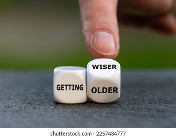 Hand turns dice and changes the expression 'getting older' to 'getting wiser'.